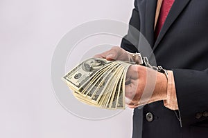 businessman hands hold dollars prisoners in handcuffs
