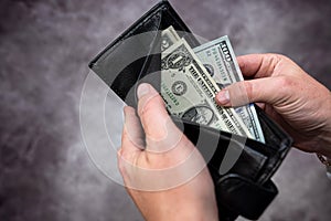 Businessman hands holding black leather wallet with dollar bills