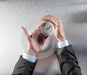 Businessman hands holding a compass, managing his career orientation