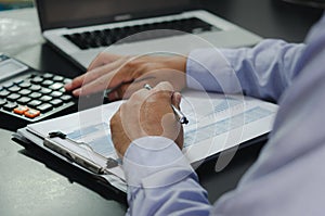 Businessman hands holding pens and business documents at desk and calculator. Business, finance, tax and investment concept