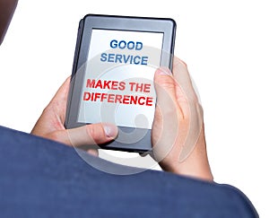 Businessman hands holding tablet with Good Service Makes The Difference sign. Business concept. Stock photo