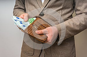 Businessman hands holding wallet with stack of money