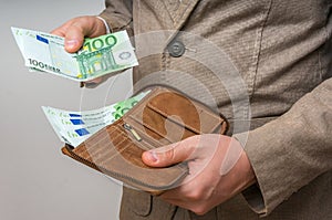 Businessman hands holding wallet with stack of money