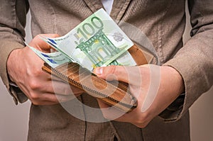 Businessman hands holding wallet with stack of money