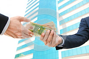 Businessman hands passing money - Euro currency (EUR) photo