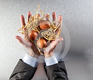 Businessman hands presenting sustainable eggs in straw for food preservation