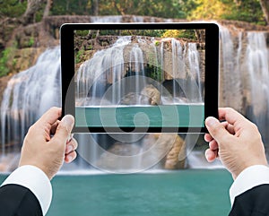 Businessman hands tablet taking pictures Waterfall deep forest