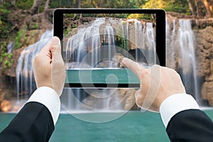 Businessman hands tablet taking pictures Waterfall deep forest