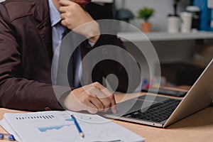 Businessman hands typing on keyboard working at desk. Business reports analyzing financial and marketing graphs document and