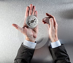 Businessman hands using a compass for vision or orientation symbol