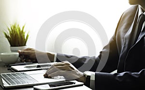 Businessman hands using keyboard of laptop computer on office desk.