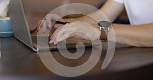 Businessman hands with watch using touchpad on laptop. Student typing on keyboard at cozy cafe. Concept of remote work