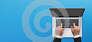 Businessman hands working laptop with copy space on blue background