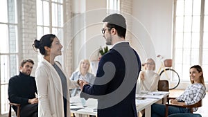 Businessman handshake congratulate excited Indian female employee