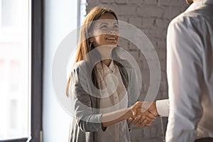 Businessman handshake excited female worker greeting with success