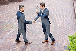 Businessman handshake with partner. Business men in suit shaking hands outdoors. Handshake. Two business team