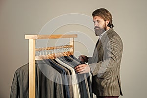 Businessman handsome guy in clothes shop choosing garments, demanding customer concept