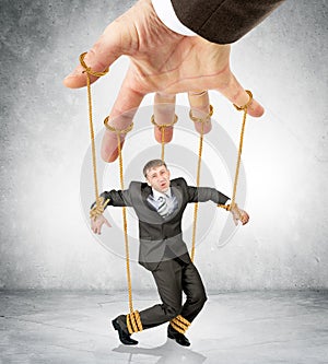 Businessman hanging on strings like marionette