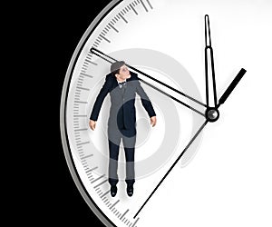 Businessman hangs on an arrow of clock
