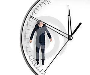 Businessman hangs on an arrow of clock