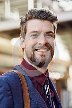 Businessman, happy and portrait in city for fashion, style and clothes with bag in street. Male person, smile and