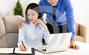 Businessman harassing colleague in office photo