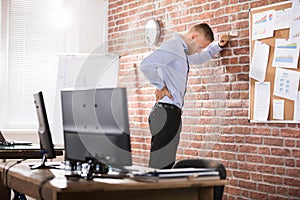 Businessman Having Back Pain In Office