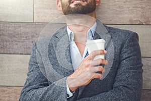 Businessman having break holding morning paper cup of c