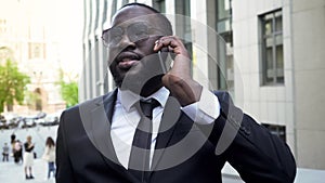 Businessman having conversation over cellphone, talk with partners, moneymaker