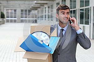 Businessman having a dramatic moment on the phone after being fired