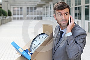 Businessman having a dramatic moment on the phone after being fired