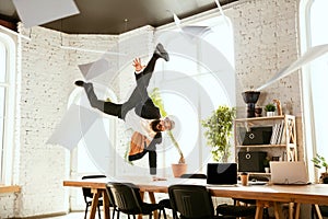 Businessman having fun dancing break dance in the office at work