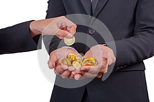 Businessman is having hands full of golden coins. Business profit concept.