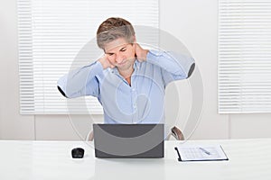 Businessman Having Neck Pain While Working On Laptop