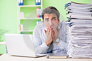 The businessman having problems with paperwork and workload