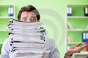 The businessman having problems with paperwork and workload photo