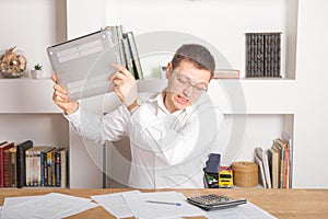 Businessman having stress with laptop computer working in the office, he is crushed laptop