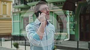 Businessman having talk on mobile phone. Man talking phone in shirt at street