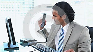 Businessman having trouble while phoning