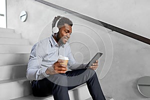 Businessman with headphones and tablet pc