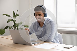 Businessman in headphones working on-line use laptop in office photo