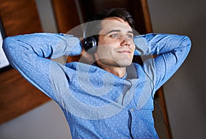 Businessman, headset and listening music in office professional, smile and relax for break. Male person, resting or