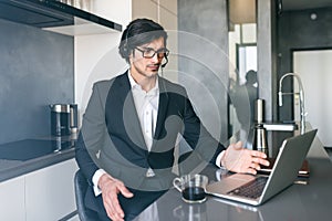 Businessman with headset at a video conference from his home computer photo