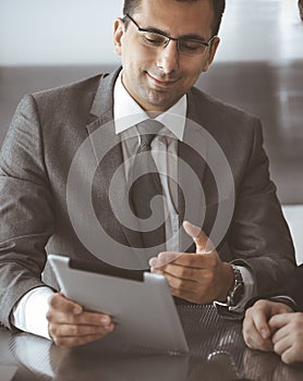 Businessman headshot at meeting in modern office. Entrepreneur sitting at the table with colleagues. Teamwork and