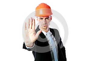 Businessman in helmet showing stop gesture