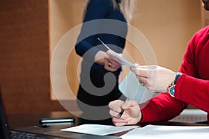 Businessman with her staff, people group in background at modern bright office indoors