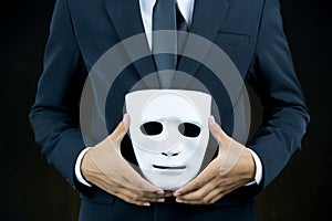 Businessman hide the white mask in the hand