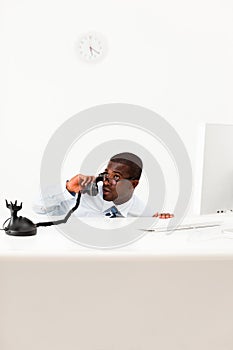 Businessman hiding behind desk