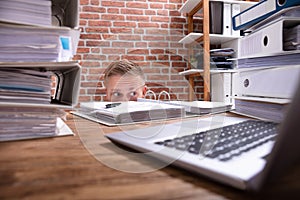 Businessman Hiding Behind The Desk photo