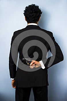Businessman hiding gun behind his back